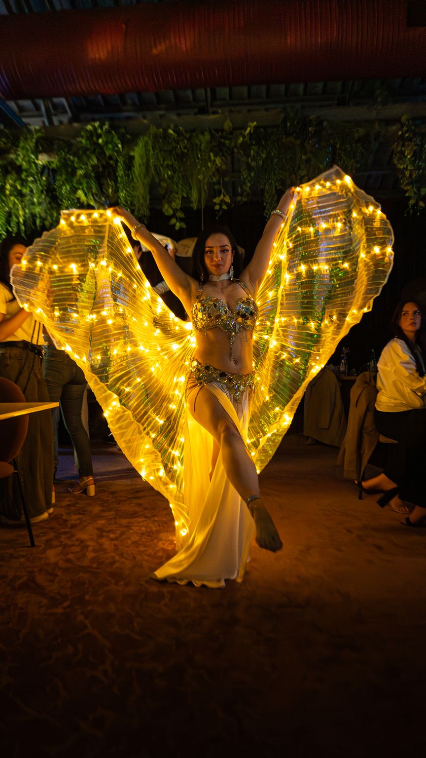 Soirée chez Carla, danseuse aux ailes lumineuses dorées